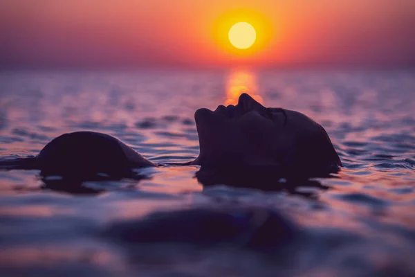 Silhueta de mulher sexy posando ao nascer do sol na praia — Fotografia de Stock