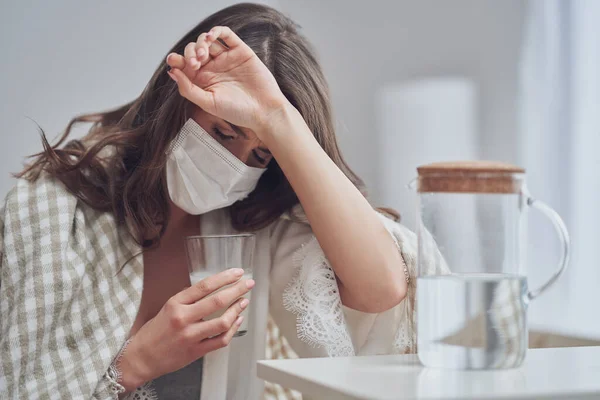 Erwachsene Frau in Maske fühlt sich zu Hause krank Covid-19-Konzept — Stockfoto