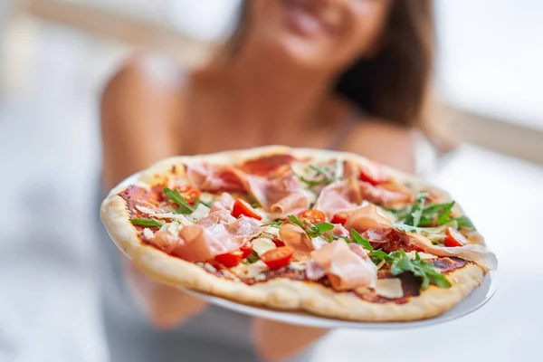 Mooie volwassen vrouw die thuis pizza eet — Stockfoto