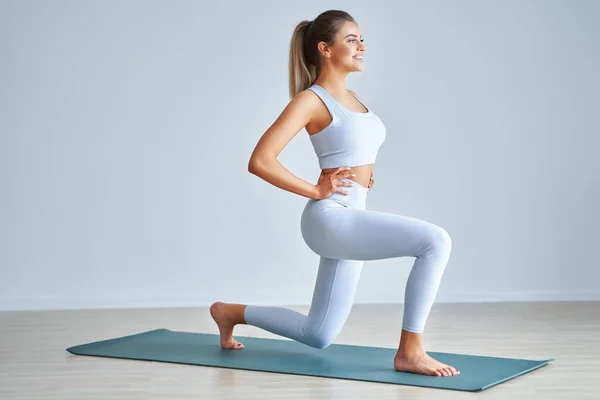 Volwassen mooie vrouw uit te werken over lichte achtergrond — Stockfoto