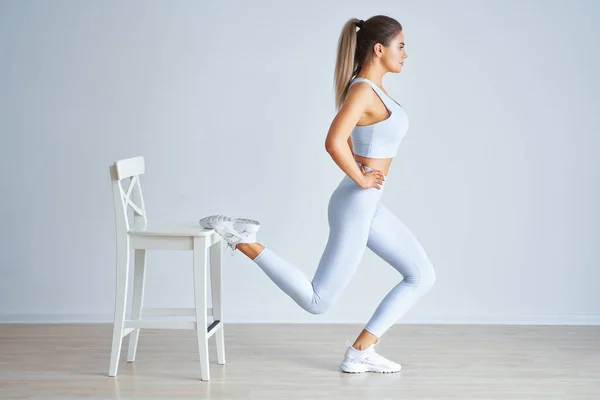 Adulto hermosa mujer haciendo ejercicio sobre fondo de luz — Foto de Stock