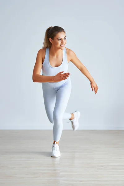 Adulto hermosa mujer haciendo ejercicio sobre fondo de luz —  Fotos de Stock