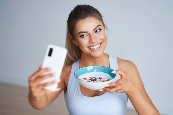 Retrato de bela mulher hispânica comendo iogurte promovendo um estilo de vida saudável — Fotografia de Stock