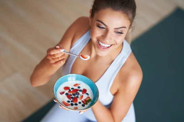 Portret van een mooie Spaanse vrouw die yoghurt eet ter bevordering van een gezonde levensstijl — Stockfoto