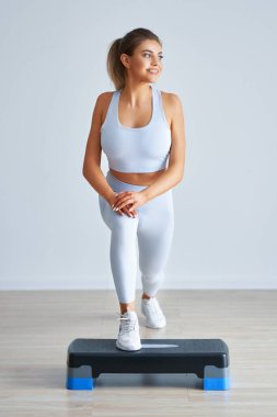 Yetişkin ve güzel bir kadın arka planda adım atarak çalışıyor.