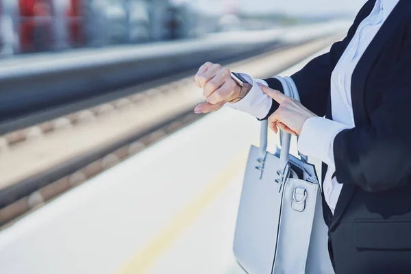 Elegante vrouw met masker lopend met tas en koffer in het station — Stockfoto