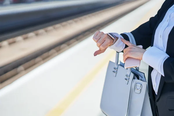 Elegantní žena kráčí s taškou a kufrem na nádraží — Stock fotografie