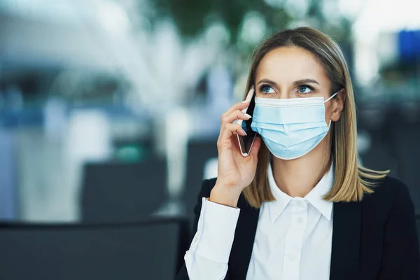 Adult female passenger using smartphone at the airport — Stock Photo, Image