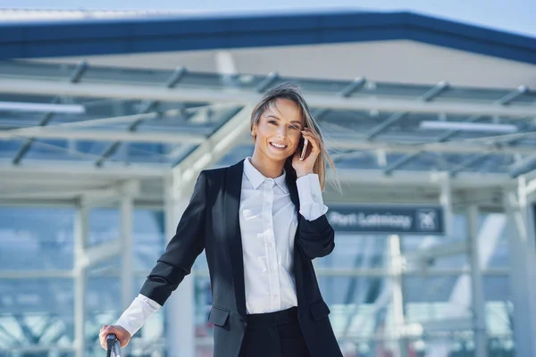 Volwassen vrouwelijke passagier met smartphone op de luchthaven — Stockfoto