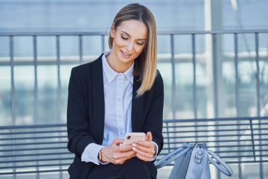 Zarif bir kadın tren istasyonunda oturup tren bekliyor.