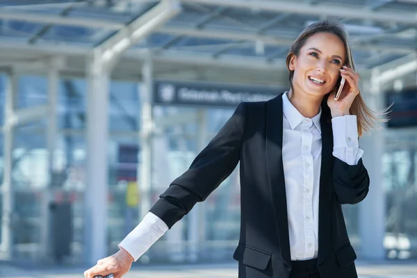Volwassen vrouwelijke passagier met smartphone op de luchthaven — Stockfoto