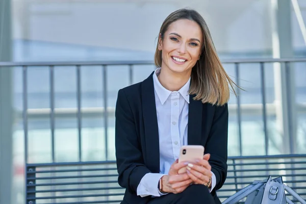 Elegancka kobieta siedzi i czeka na pociąg na dworcu kolejowym — Zdjęcie stockowe