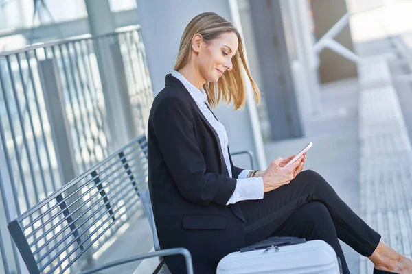 Elegante vrouw zit en wacht op de trein in het station — Stockfoto