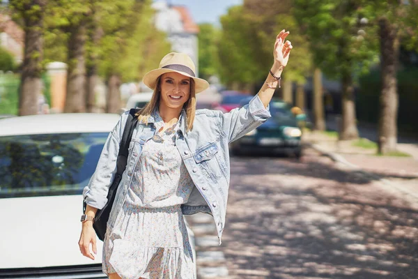 Een persoon met een hoed op die een taxi neemt. — Stockfoto