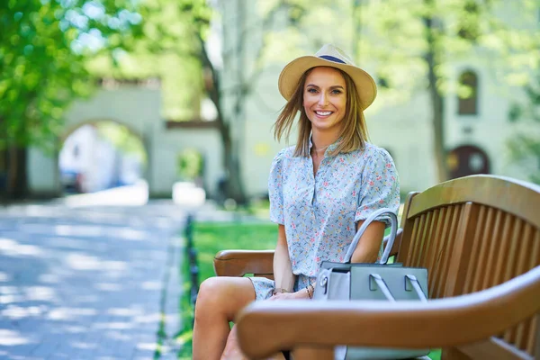 Una buena chica feliz sentada en un banco —  Fotos de Stock