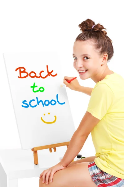 Young girl painting back to school on an easel — Stock Photo, Image