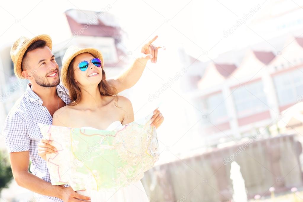 Romantic couple sightseeing with a map