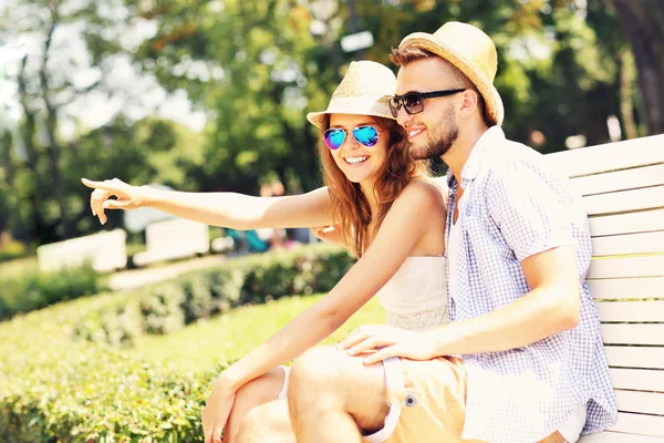 Young couple sitting on a bench — Stock Photo, Image