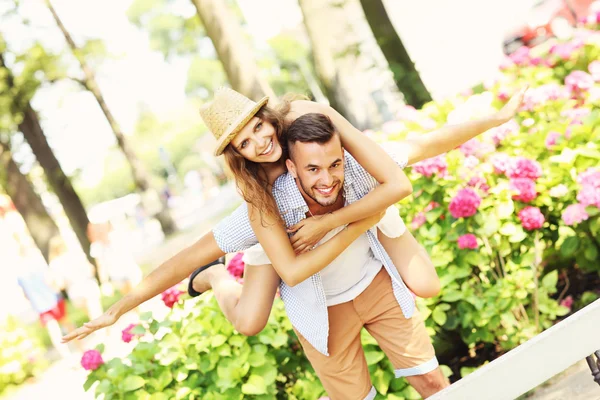 Romantic couple doing piggyback in the park — Stock Photo, Image