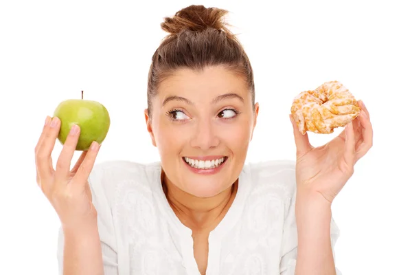 Woman choosing between apple and donut Royalty Free Stock Images