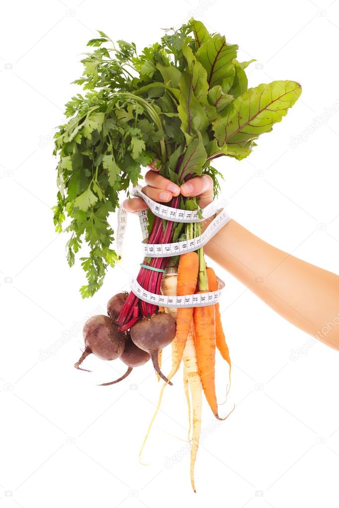 Vegetables tape measure and hand