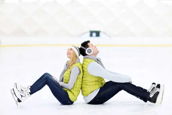 Casal alegre sentado na pista de patinação — Fotografia de Stock