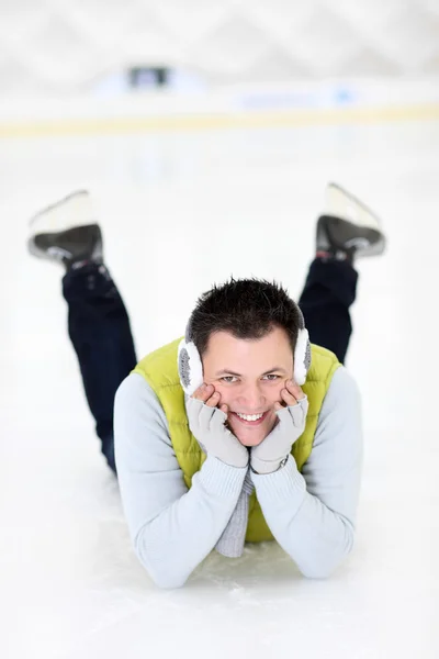 Hombre alegre acostado en una pista de patinaje — Foto de Stock
