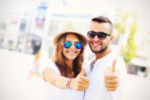 Feliz pareja de turistas mostrando bien en la ciudad —  Fotos de Stock