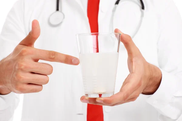 Midsection de un médico sosteniendo un vaso de agua con la píldora — Foto de Stock