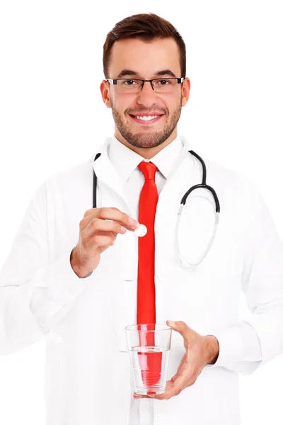 Medico sosteniendo la píldora y vaso de agua — Foto de Stock