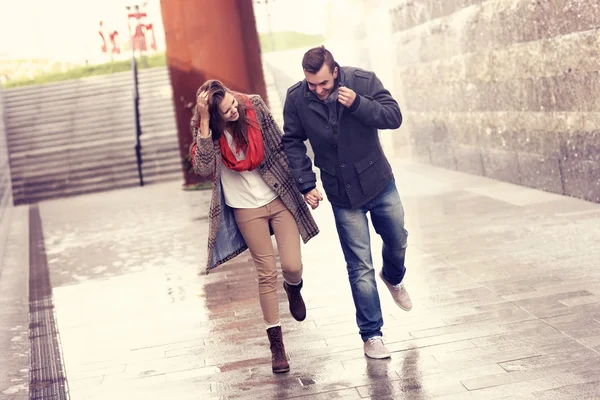 Casal correndo na chuva — Fotografia de Stock