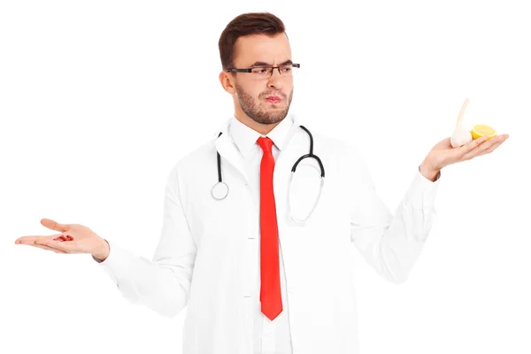 Doctor holding pills and lemon with garlic — Stock Photo, Image