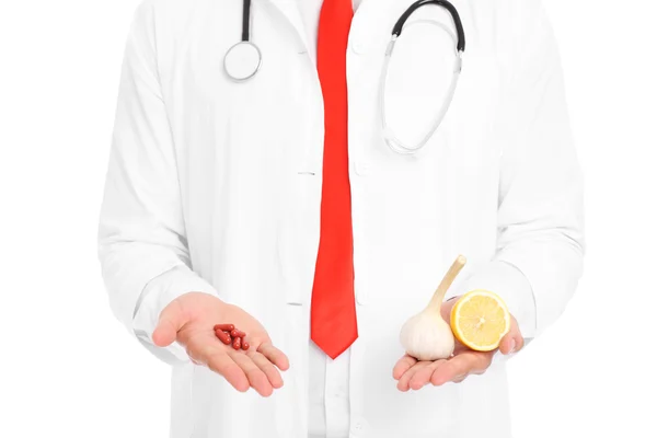 Midsection doktor holding piller och citron med vitlök — Stockfoto