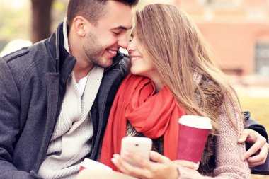 Romantik Çift ile smartphone parkta bir bankta