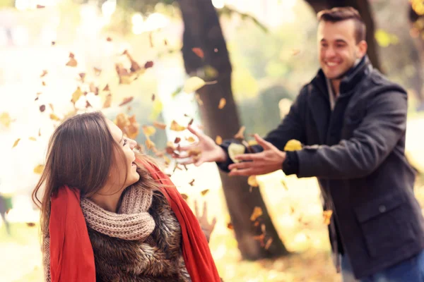 Pareja feliz divirtiéndose en el parque en otoño — Foto de Stock