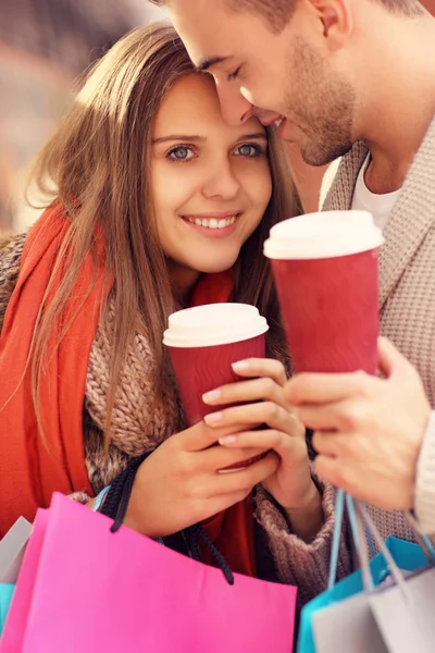 Gelukkige paar met koffie winkelen in de mall — Stockfoto