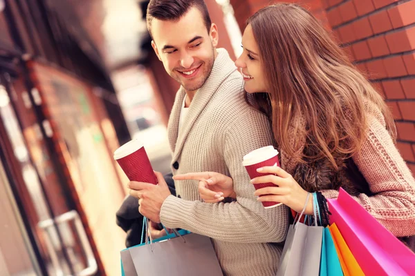 Gelukkige paar met koffie winkelen in de mall — Stockfoto