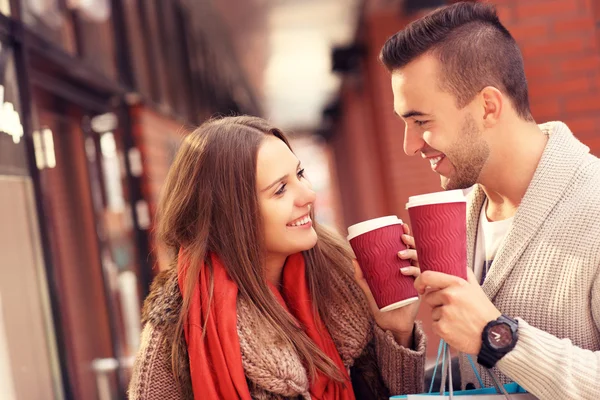 Mladý pár s kávou nakupovat v nákupním středisku — Stock fotografie