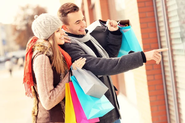 Pareja joven ventana de compras en la ciudad —  Fotos de Stock