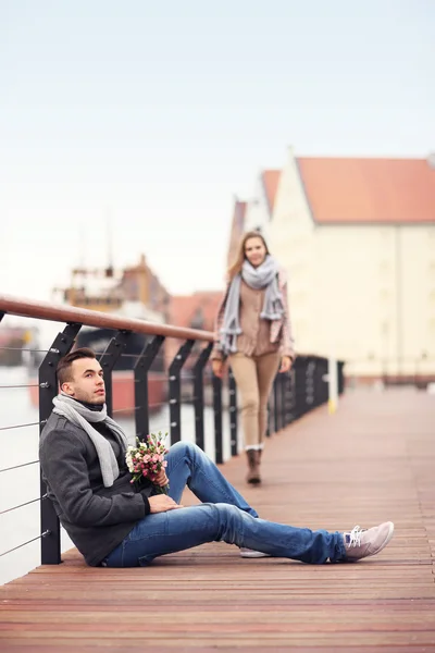 Man väntar på en kvinna med blommor — Stockfoto