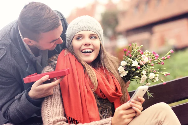 Mand giver overraskelse gave til kvinde i parken - Stock-foto