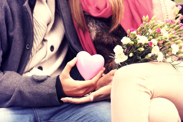 Midsection of a romantic couple sitting on a bench — Stock Photo, Image