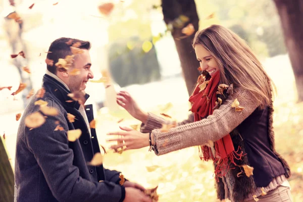 Casal feliz se divertindo no parque no outono — Fotografia de Stock