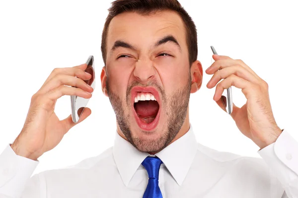 Hombre de negocios enojado hablando en dos teléfonos — Foto de Stock