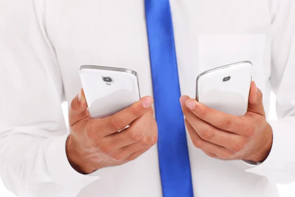 Бизнесмен с двумя смартфонами — стоковое фото