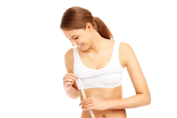 Счастливая женщина измеряет свою грудь — стоковое фото