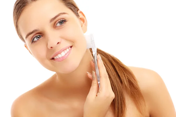 Woman cleaning face with a brush — Stock Photo, Image