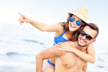 Genç çift sahilde bir şey işaret