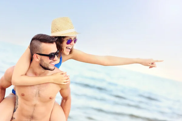 Ungt par pekar på något på stranden — Stockfoto