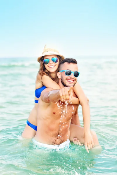 Casal feliz se divertindo na praia — Fotografia de Stock